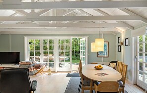 Relax in this stylish room with a large dining table, comfortable sofa, and TV, plus a patio with outdoor seating.