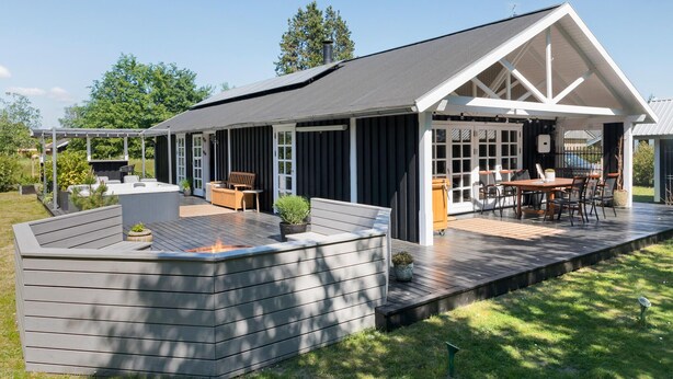 A modern house with a covered patio, outdoor seating, and a fire pit. - Awesome home in Rødby with sauna (Rødby)