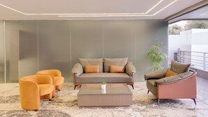 Un salon moderne avec un canapé, deux fauteuils et une table basse.