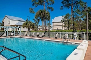 A swimming pool with lounge chairs and a pergola, surrounded by trees and buildings. - Golf Cart, 6 Bikes! Walk to the Pool & the Beach! ~ My Happy Place on 30A (Santa Rosa Beach)