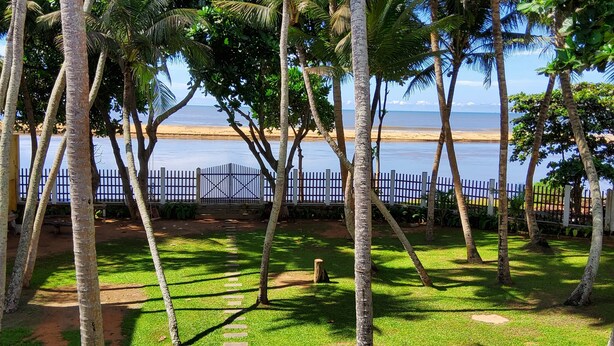 A view of a beach with palm trees and a fence in the foreground. - Villa Inlet Galle (Galle)