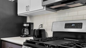 Une cuisine équipée d’une cuisinière, d’une machine à café et d’un grille-pain.
