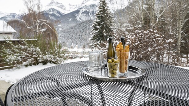 Ein Tisch aus Metall mit einer Tablett, auf dem Flaschen, Gläser und Oliven stehen.