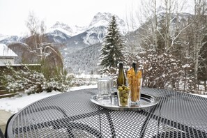 A metal table with a tray containing bottles, glasses, and olives.