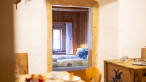 Una stanza accogliente con un letto, un tavolo con una tazza e un piattino, e una sedia.