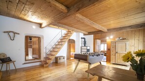 A wooden-floored room with a foosball table, a staircase, and a wooden door. - Chasa Riatsch: Renovated Engadine house in the centre of Ardez (Ardez)