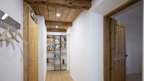 A hallway with wooden flooring, a wooden ceiling, and a bookshelf with various items. - Chasa Bijou: Idyllic 3-room apartment in the quiet mountain village of Ftan (Ftan)