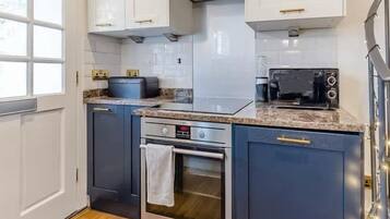 A compact kitchen with a built-in oven, a microwave, and a toaster.