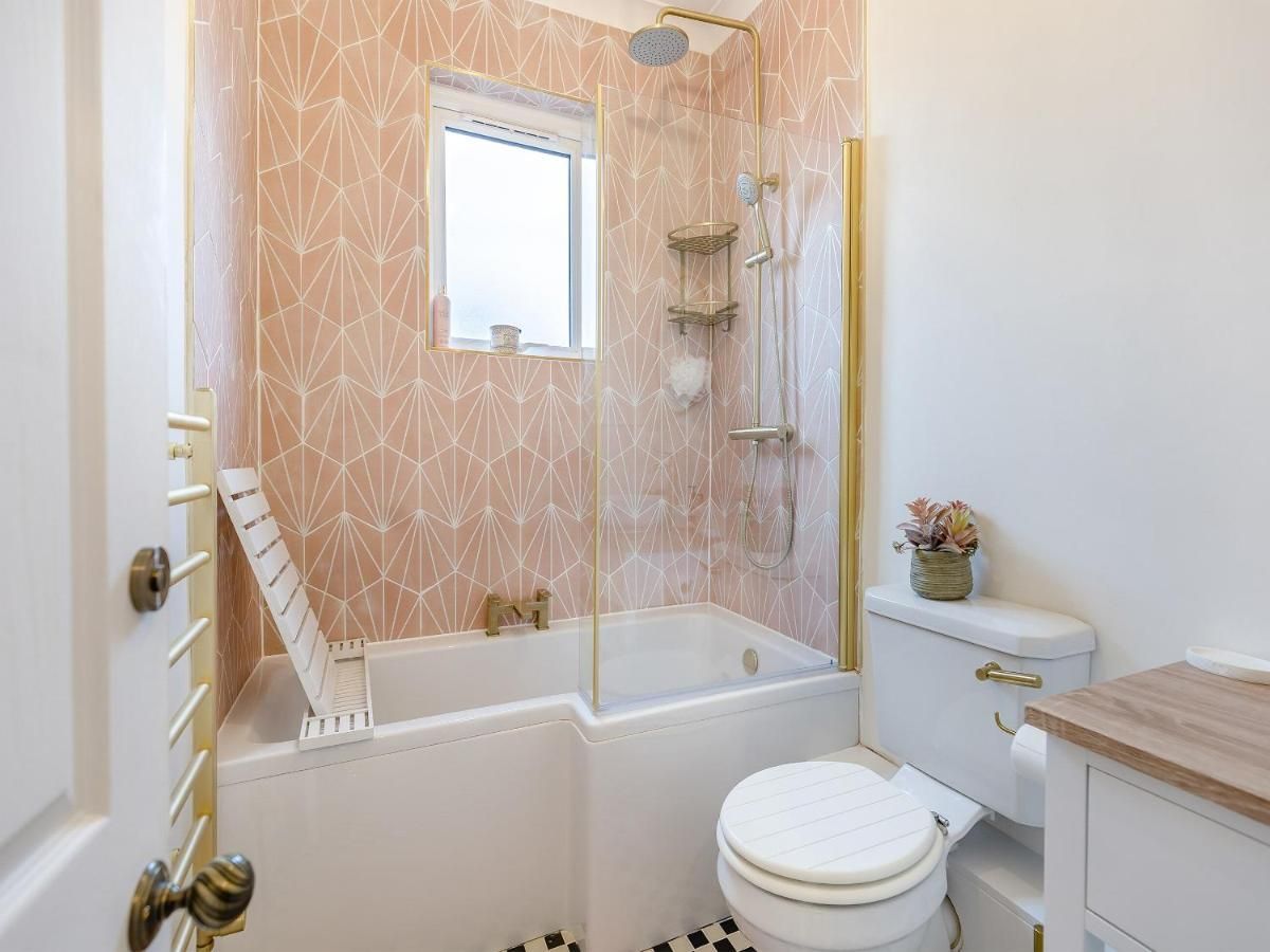 Un baño con bañera, inodoro y ventana.