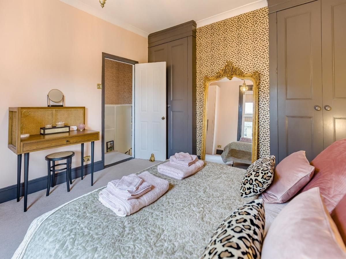 Una camera da letto con un letto, una scrivania, una sedia e uno specchio.