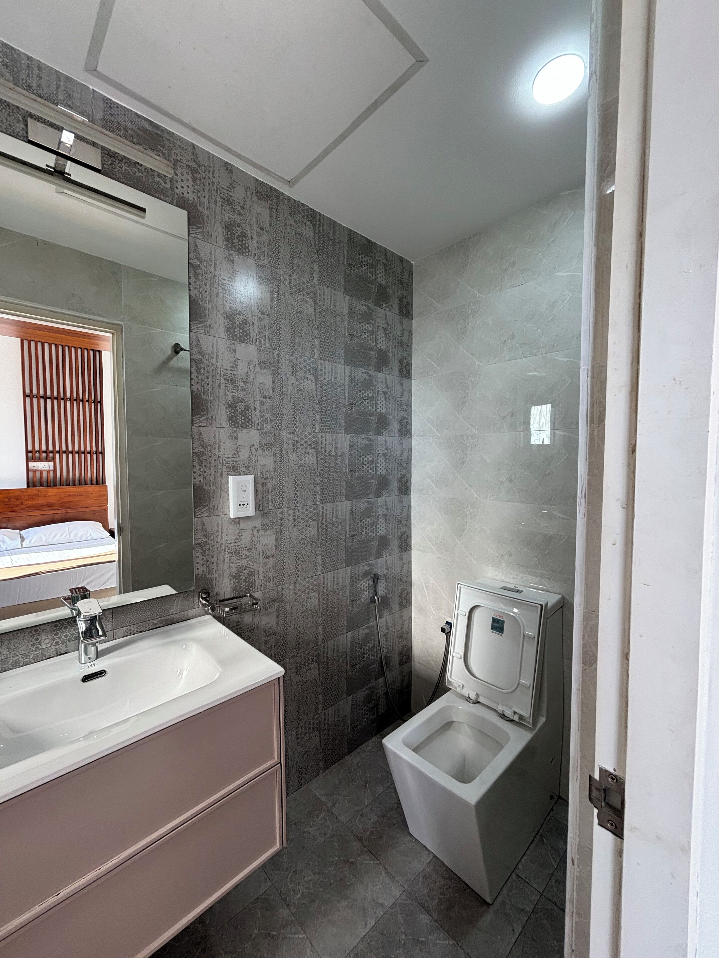 A bathroom with a double sink, a toilet, and a shower.