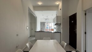 Una sala de conferencias moderna con una mesa larga y seis sillas, un ventilador de techo e iluminación empotrada.