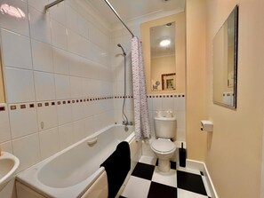 A bathroom with a bathtub, toilet, and sink. - Captivating 1-bed Apartment in Cambridge (Cambridge)