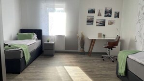 Un dormitorio con cama, escritorio y silla.