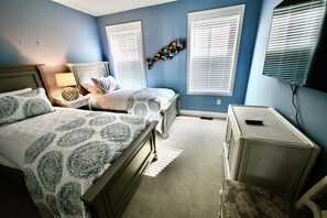 A bedroom with two beds, a dresser, a TV, and a wall art piece. - New Listing: Bayside Resort Fenwick Island at The Point - Luxury (Selbyville)