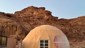 A geodesic dome tent with a door and windows, set against a rocky desert backdrop. - Jabal Rum camp (Wadi Rum)
