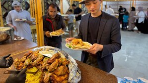A buffet with roasted chicken and rice, a man serving food, and a man in a chef's outfit in the background. - Jabal Rum camp (Wadi Rum)