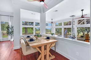 Un espace repas avec une table en bois, des chaises et une vue sur l’extérieur.