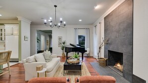 Un salon agr émenté d’un magnifique piano à queue, d’une cheminée et d’un coin salon confortable.