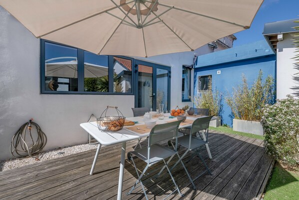 An outdoor dining area with a table, chairs, and an umbrella. - 500m Libraires beach - Pornichet (Pornichet)