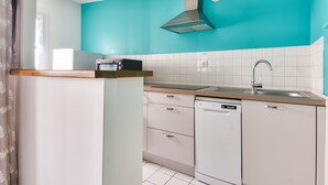 A kitchen with white cabinets, a dishwasher, a sink, and a stove.