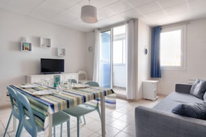 Enjoy a comfortable stay in this well-appointed living space with a flat-screen TV, dining table, and plush sofa.
