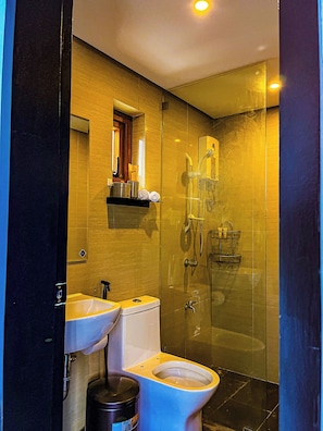 Un baño moderno con ducha de vidrio, inodoro y lavabo.