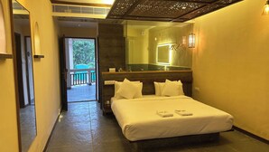 A hotel room with a bed, a large mirror, and a view of a balcony. - Avhyay Resort (Vasai)