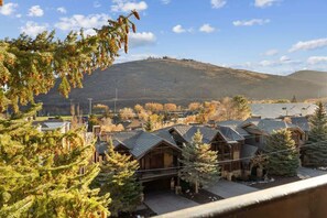 A residential area with houses featuring sloped roofs and a mountainous backdrop.