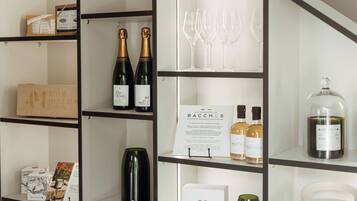 Exhibición de vino y copas con botellas y vasos en estantes.