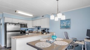 A modern kitchen with white cabinets, stainless steel appliances, and a central island with placemats.