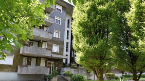 A multi-story residential building with balconies, a central staircase, and surrounding greenery. - VACATION HOME EL'GIO HOME PORDENONE (Pordenone)