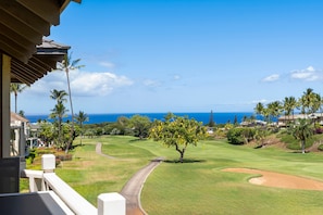 A golf course with a clear view of the ocean and a residential area with houses and palm trees. - Wailea Grand Champion, #90 2 Bedroom Condo by RedAwning (Kihei)