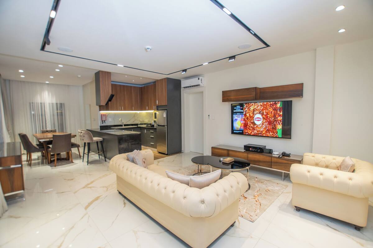 A modern living room with a sofa, a coffee table, and a TV mounted on the wall.