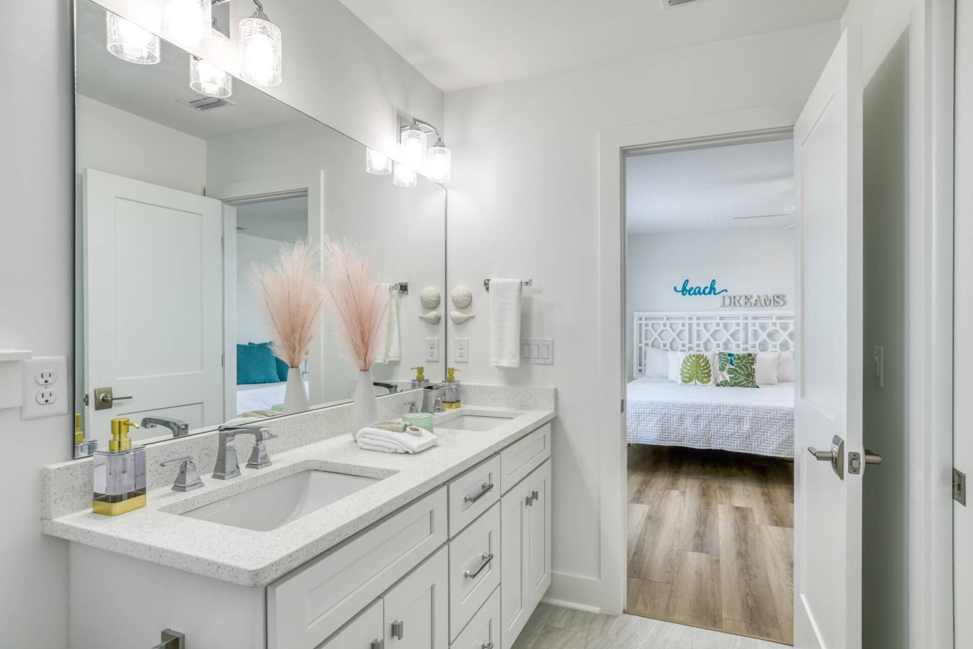 Une salle de bain moderne avec un double vasque, un grand miroir et des plantes décoratives.