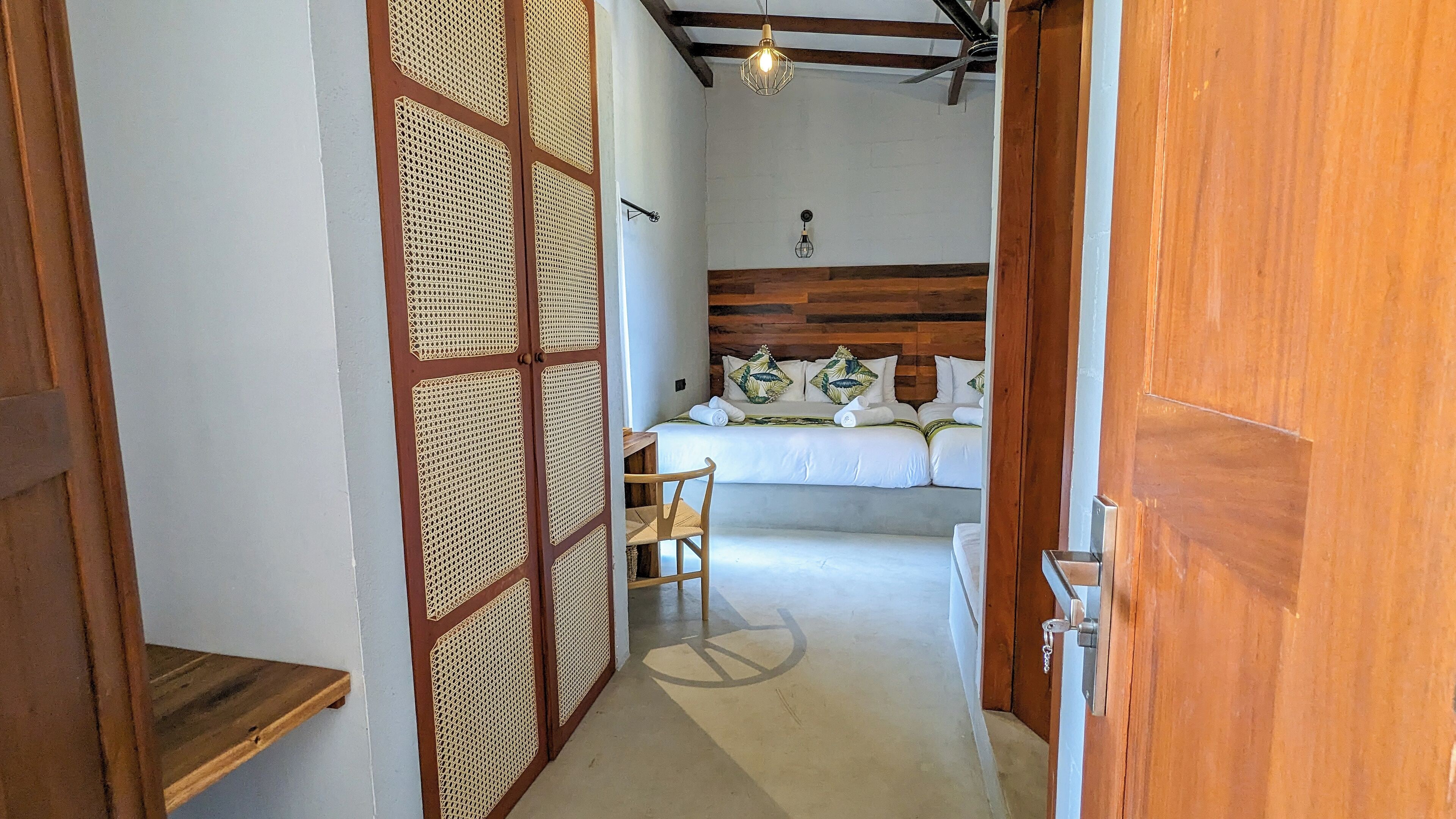 Une chambre à coucher avec un lit, une chaise et une cloison en bois.