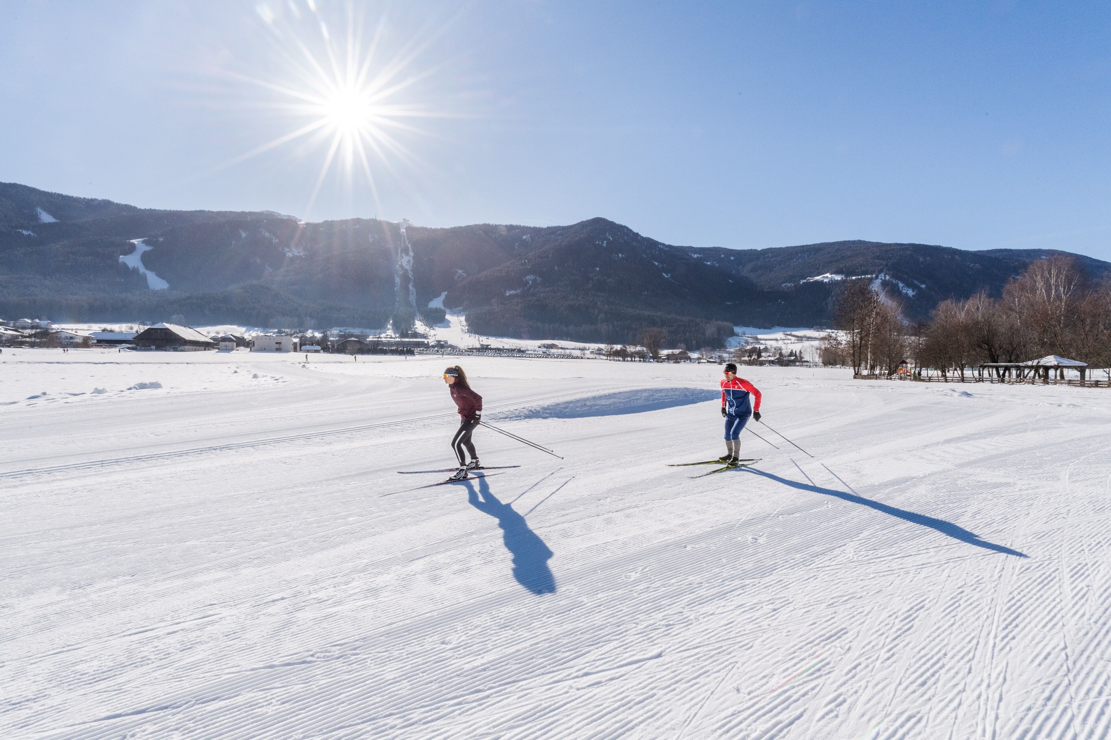Un paysage enneigé avec deux skieurs.