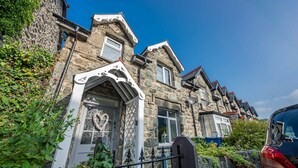 A stone building with a traditional design, featuring a prominent arched entrance and multiple windows.