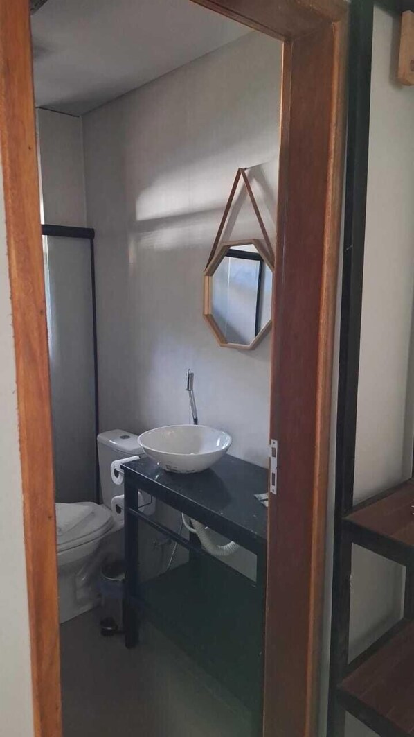 A small bathroom with a white sink, a mirror, and a toilet. - Lago São Franscisco Parque Hotel (Garanhuns)