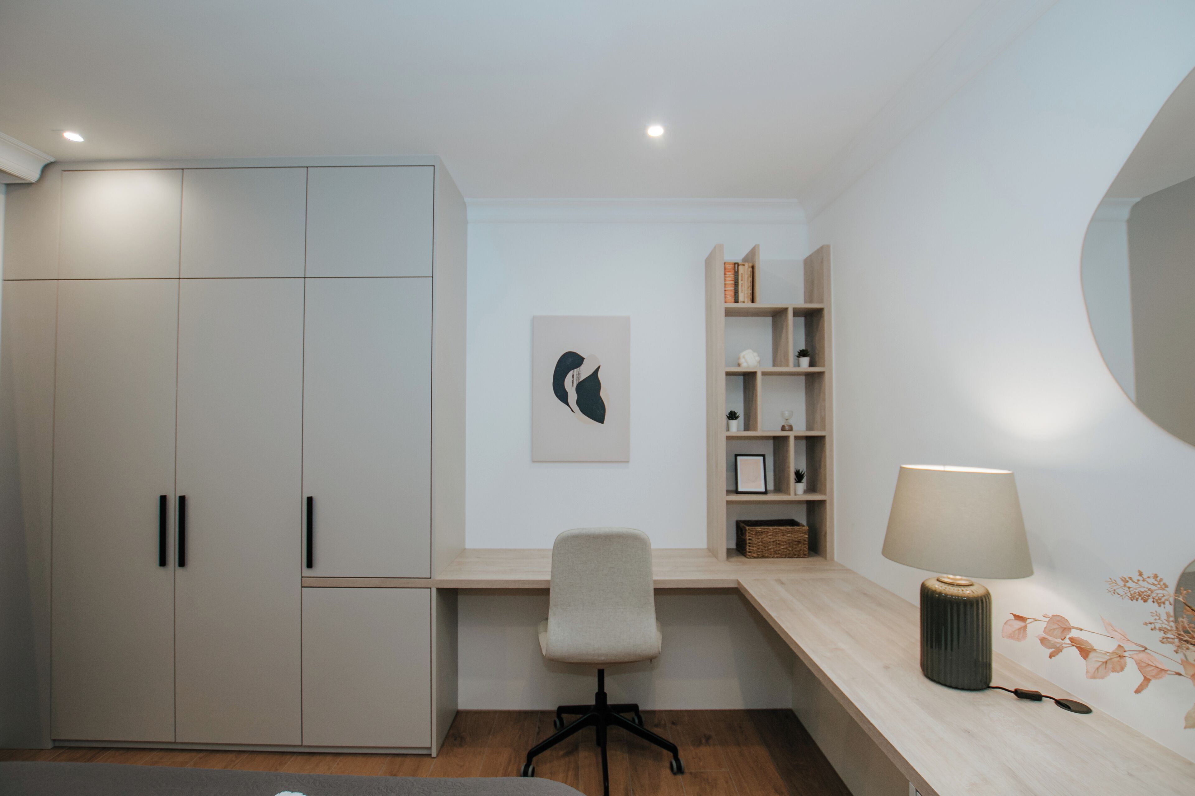 Un dormitorio moderno con cama, escritorio y armario.