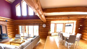 A log cabin interior with a fireplace, sofa, dining table, and chairs. - Magical Retreat up to 20 People (St. Peter`s)