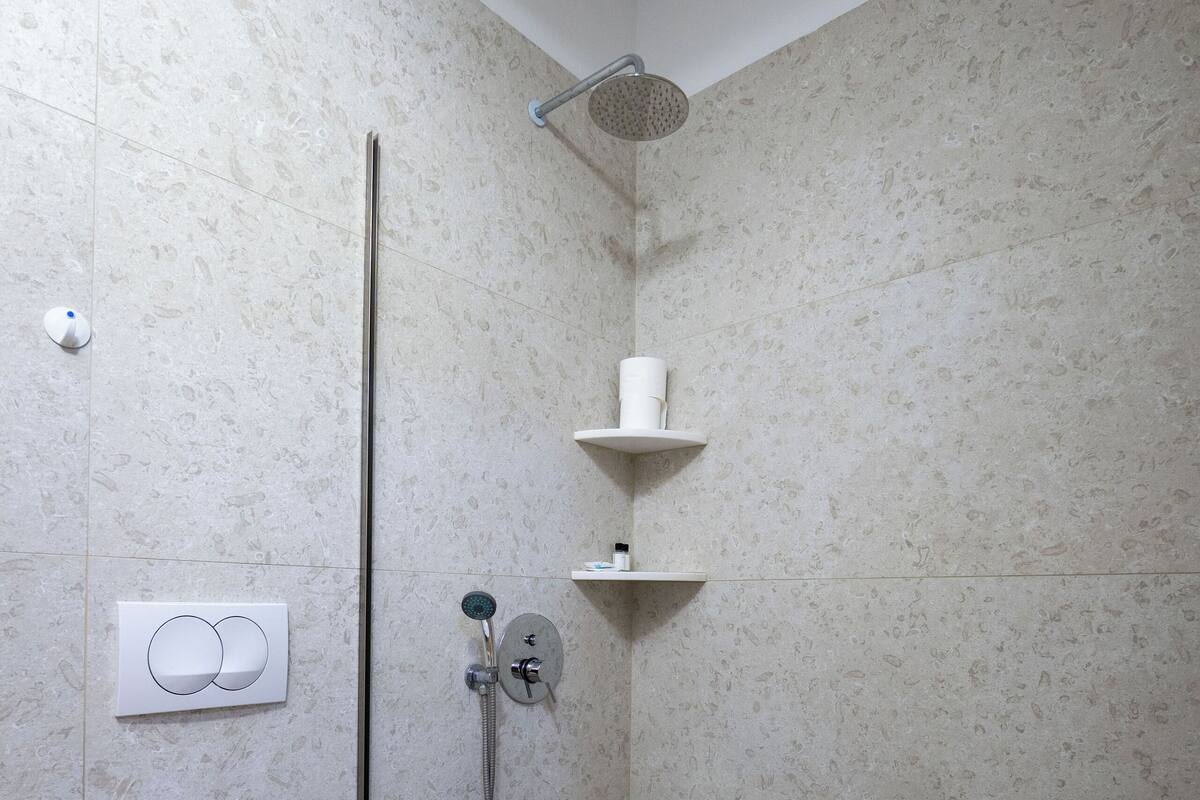 A modern bathroom with a toilet, shower, and towel rack.