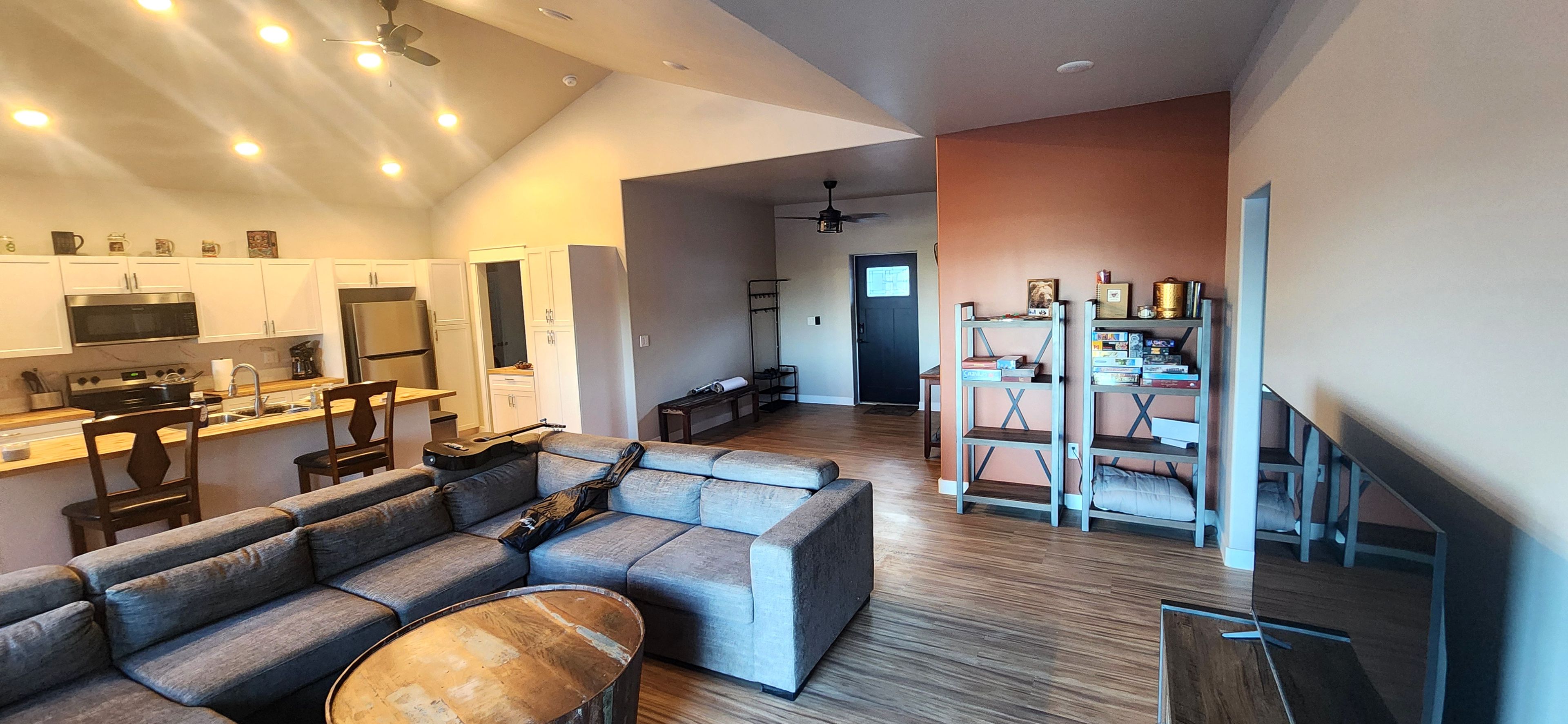 A modern interior with a kitchen, living area, and a staircase leading to another level.