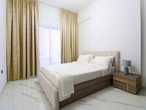 Une chambre à coucher moderne avec un lit, des rideaux, une table de chevet et une lampe.