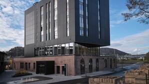 A modern building with the name "NOXX" on the facade, featuring large windows and a brick base. - Noxx Hotel (Marburg)