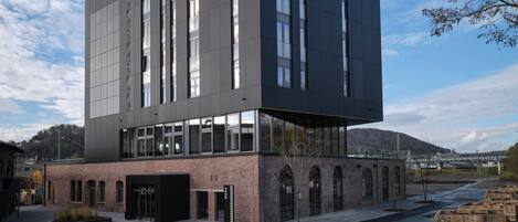Ein modernes Gebäude mit dem Schriftzug "NOXX" auf der Fassade, mit großen Fenstern und einer Ziegelbasis.