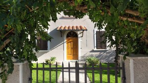 A house with a wooden door, a tiled roof, and a black metal fence. - "A CASA DI FRANCA" PRIVATE VILLA IN CHIANTI
A RURAL REFUGE FOR FAMILIES (Gambassi Terme)