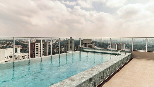 A rooftop infinity pool with a city view, surrounded by glass railings. - 360 Ver.de Panorama  (São Paulo)