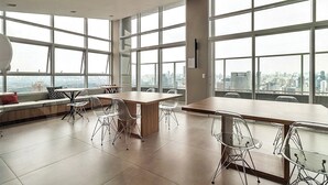 A spacious office with large windows, a high ceiling, and a city view. - 360 Ver.de Panorama  (São Paulo)