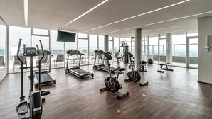 A spacious gym with various exercise equipment, large windows, and a high ceiling. - 360 Ver.de Panorama  (São Paulo)